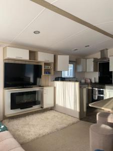 a living room with a kitchen with a large appliance at Lemon Grove in Mudeford