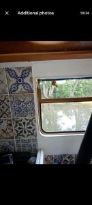 a window on a train with tiles on the wall at Cosy, secluded narrow boat in Airton