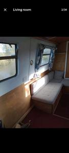 a small room on a train with two windows at Cosy, secluded narrow boat in Airton