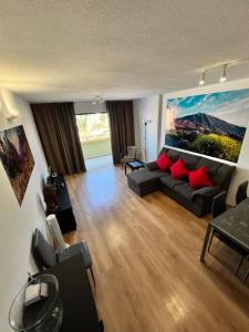 sala de estar con sofá y almohadas rojas en Family apartment “Tenerife with love!”, en Arona
