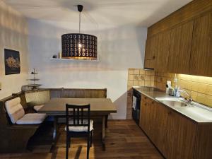 uma cozinha com uma mesa e cadeiras e um lavatório em Sonnenzauber em Andermatt