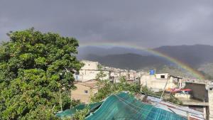 einen Regenbogen über einer Stadt mit Gebäuden und Bäumen in der Unterkunft LA CASA DEL ÁRBOL ABANCAY in Abancay