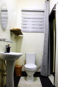 Łazienka z białą toaletą i umywalką w obiekcie Accra Luxury Apartments At The Sanga Estates w Akrze