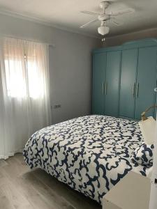 1 dormitorio con 1 cama y armario azul en Preciosa casa entera con patio, en Zarza de Granadilla