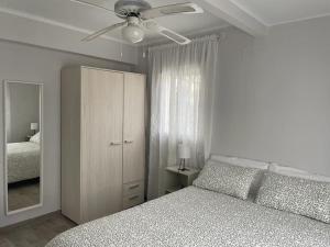 1 dormitorio con 1 cama y ventilador de techo en Preciosa casa entera con patio, en Zarza de Granadilla