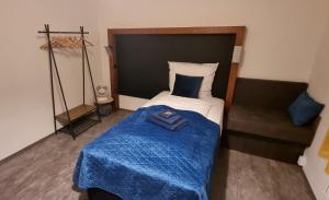 a small bedroom with a bed with a blue blanket at Fine Living - Einzeln oder größere Gruppen- 5 Zimmer je mit eigenem Bad - Küche - Aufenthaltsraum - bis 8 Personen in Meine