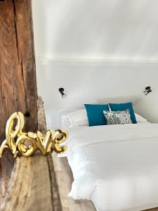 a bedroom with a white bed and blue pillows at Le Gite de Florian in Chablis
