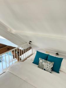 een slaapkamer met een wit bed met blauwe kussens bij Le Gite de Florian in Chablis