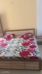 Una cama con un edredón con rosas rojas. en Arhan's Villa, en Ahmedabad