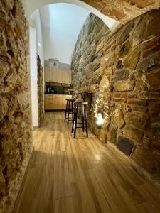 a kitchen with a stone wall and a table at Maison Costa Masciarelli in LʼAquila
