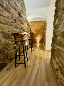 Maison Costa Masciarelli في لاكويلا: غرفة بها طابقين أمام جدار حجري