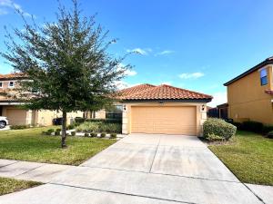 a house with a garage and a tree at Villa with Pool in Gated 18-hole Golf Community with self-checkin after 4pm in Davenport