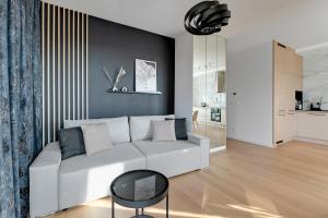 uma sala de estar com um sofá branco e uma parede preta em Doki - Montownia View by Grand Apartments em Gdansk