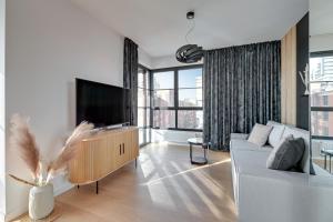 uma sala de estar com um sofá e uma televisão de ecrã plano em Doki - Montownia View by Grand Apartments em Gdansk