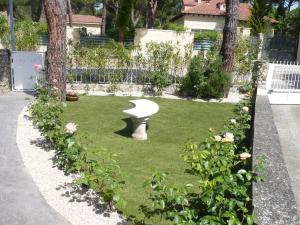 um jardim com um banco branco na relva em Villa Lujosa con piscina privada 9x5 em Valladolid