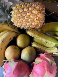 a pile of fruit including bananas and pears and a pineapple at La Campierelle in Salazie +18 photos