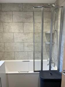 a glass shower in a bathroom with a tub at Fresh, fully equipped modern house can sleep 5 in Kiveton Park