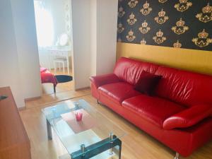 a living room with a red couch and a glass table at Sweet apartment in Bratislava