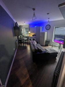 a living room with a couch and a kitchen at Bright & Modern Apartment in Hackney Wick E3 in London