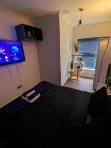 a bedroom with a bed and a tv on the wall at Bright & Modern Apartment in Hackney Wick E3 in London