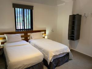 two beds sitting next to each other in a bedroom at Belvoir Apart-Hotel & Residence in Freetown