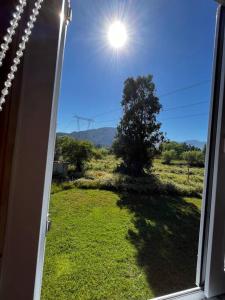 une fenêtre avec vue sur une cour arborée dans l'établissement RanchoJC Tranquilidad Naturaleza, à Colbún