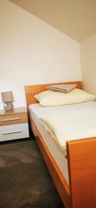 a bedroom with a bed and a night stand with a lamp at Apartments Mario in Drvar