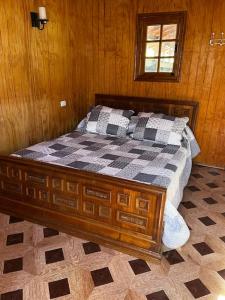 - une chambre avec un lit dans une pièce en bois dans l'établissement RanchoJC Tranquilidad Naturaleza, à Colbún