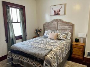 a bedroom with a bed with a cow picture on the wall at The Ely Airbnb in Ely