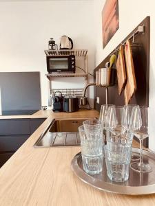 une cuisine avec des verres sur un plateau sur un comptoir dans l'établissement Frisch renovierte Fewo, in zentraler Lage, à Sellin