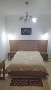 1 dormitorio con 1 cama y una pintura en la pared en Appartement résidence Port yasmine hammamet, en Hammamet