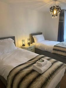 um quarto de hotel com duas camas com toalhas numa cadeira em The Flat in central Kirkby Stephen em Kirkby Stephen