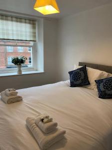 a bedroom with towels on a bed with a window at The Flat in central Kirkby Stephen in Kirkby Stephen