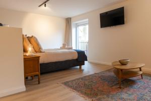 um quarto com uma cama e uma televisão na parede em Li Ter Hôtel em Marche-en-Famenne