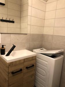 uma pequena cozinha com um lavatório e um fogão em Maison proche du centre ville - Mitoyenne em Saint-Dié-des-Vosges