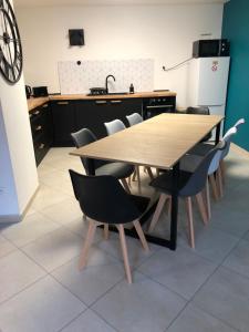 una mesa de madera y sillas en la cocina en Maison proche du centre ville - Mitoyenne en Saint Die