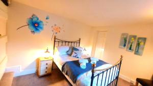 a bedroom with a bed with a blue flower on the wall at Dolgun Uchaf Guesthouse and Cottages in Snowdonia in Dolgellau