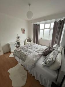 a bedroom with a large bed and a window at Cosy two bedroom flat in London