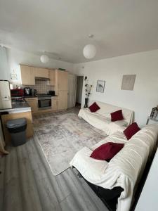 a living room with two beds and a kitchen at Cosy two bedroom flat in London