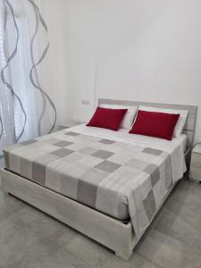 a bedroom with a large bed with red pillows at CASA VERDi 37 CAMERA RUBINO SMERALDO in Porto SantʼElpidio