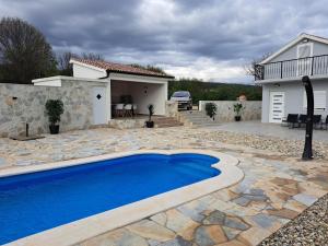a blue swimming pool in front of a house at Villa Ana in Posedarje