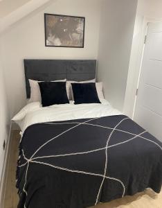 a bedroom with a bed with a black and white comforter at London Luxury Apartments in High Wycombe in Buckinghamshire