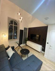 a living room with a blue couch and a tv at London Luxury Apartments in High Wycombe in Buckinghamshire