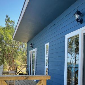 a blue house with a porch and windows at Cabañas Lakü in Ñilque