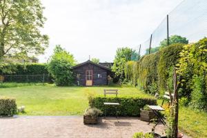 um jardim com um banco e uma cerca e uma casa em Gastenverblijf in Belle epoque woning em Bruges