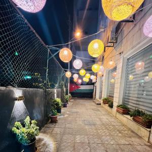 Sandra Hotel في عمّان: ممر به أضواء ونباتات خزفية على مبنى