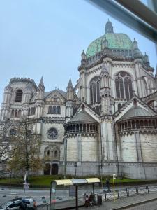 une grande cathédrale avec un grand bâtiment avec un dôme vert dans l'établissement Chambre hôte, à Bruxelles