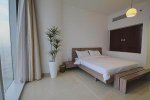- une chambre avec un lit et une plante en pot dans l'établissement private Suite by Golden Hospitality 98, à Riyad