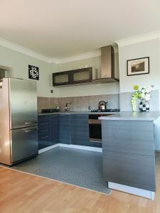 a kitchen with blue cabinets and a stainless steel refrigerator at Apartament nad Potokiem in Piechowice