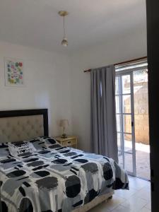 Schlafzimmer mit einem schwarzen und weißen Bett und einem Fenster in der Unterkunft Totito in Villa Mercedes